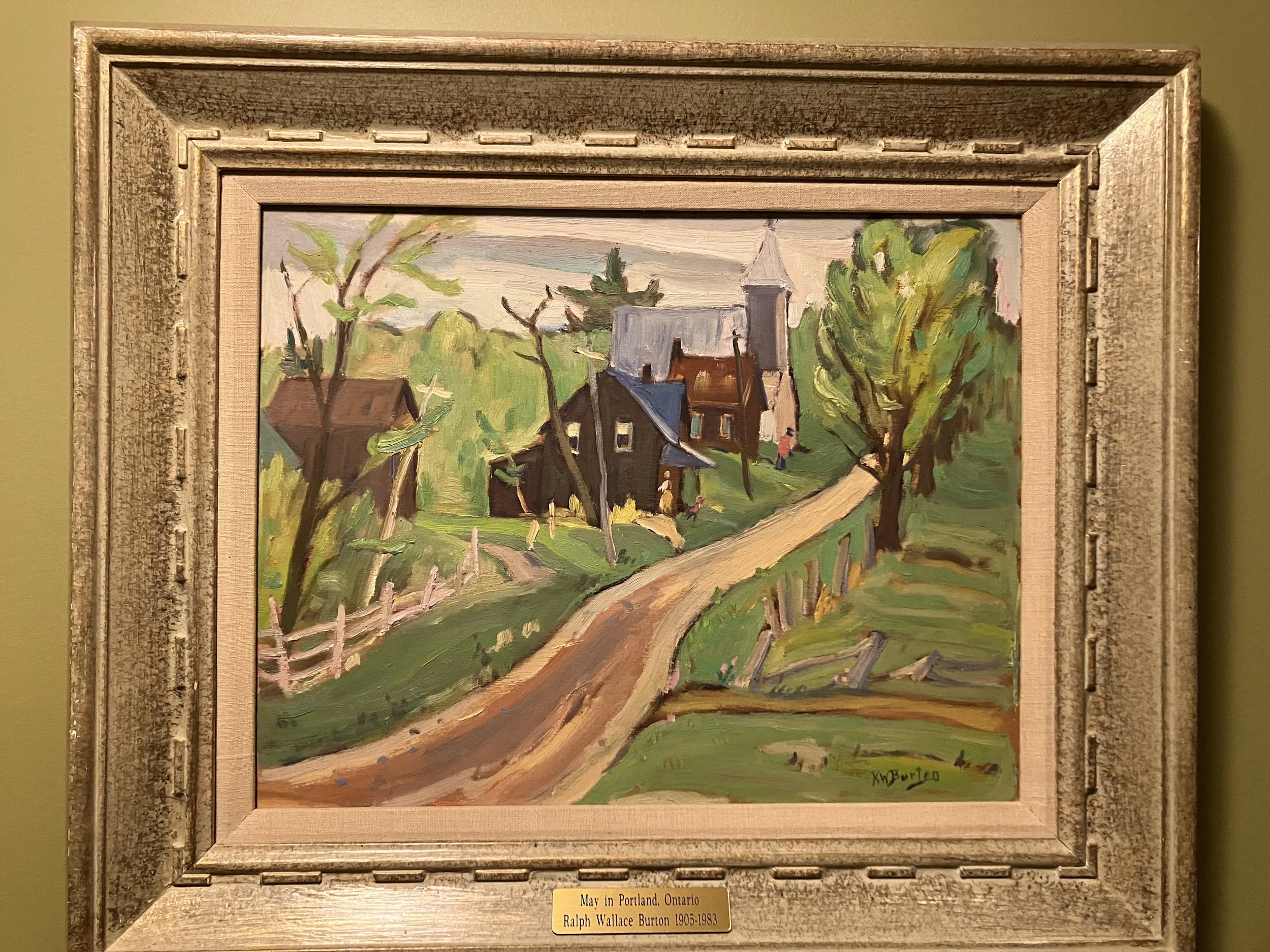 This framed artwork is a Canadian landscape painting titled "May in Portland, Ontario" by the artist Ralph Wallace Burton (1905–1983). 
Artist: Ralph Wallace Burton, a distinguished painter from the Ottawa Valley and a student of A.Y. Jackson. 
Subje