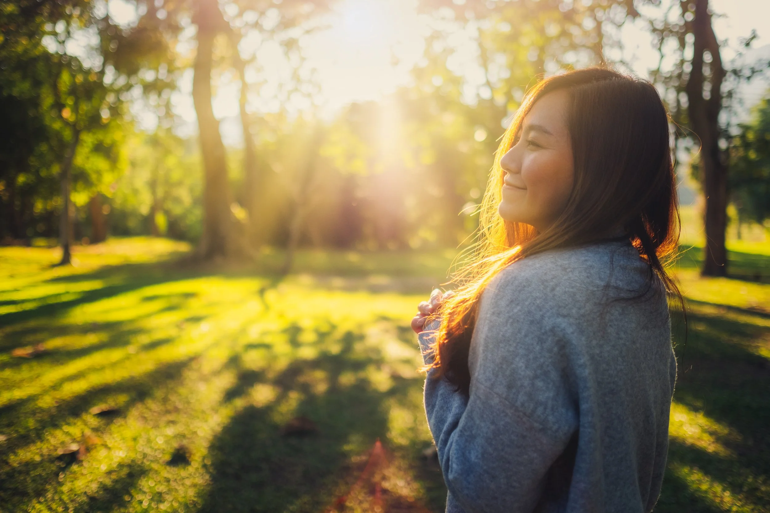 Woman enjoying a peaceful walk through a sunlit park