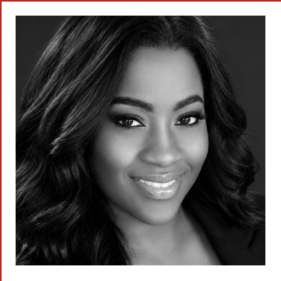 Black and white portrait of a woman with long, wavy hair, smiling and looking at the camera.
