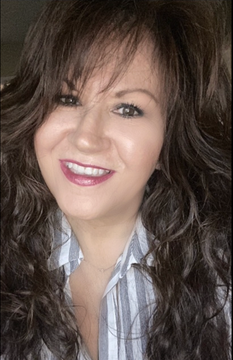 Lisa Duarte, A woman with long curly brown hair smiling at the camera, wearing a striped shirt.