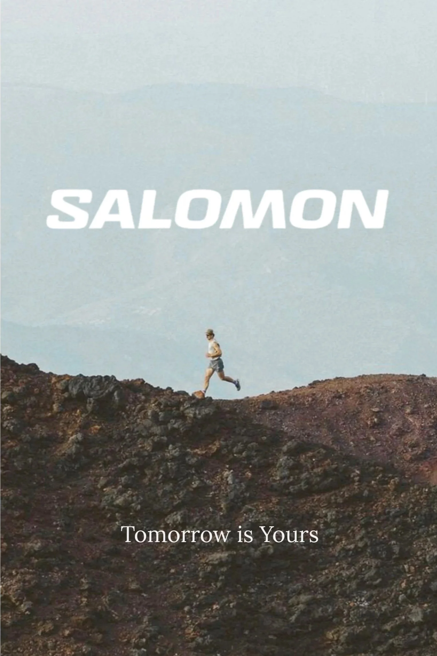A person running on a rocky terrain with a clear sky background. The text 'SALOMON' is displayed at the top, and 'Tomorrow is Yours' is written at the bottom.