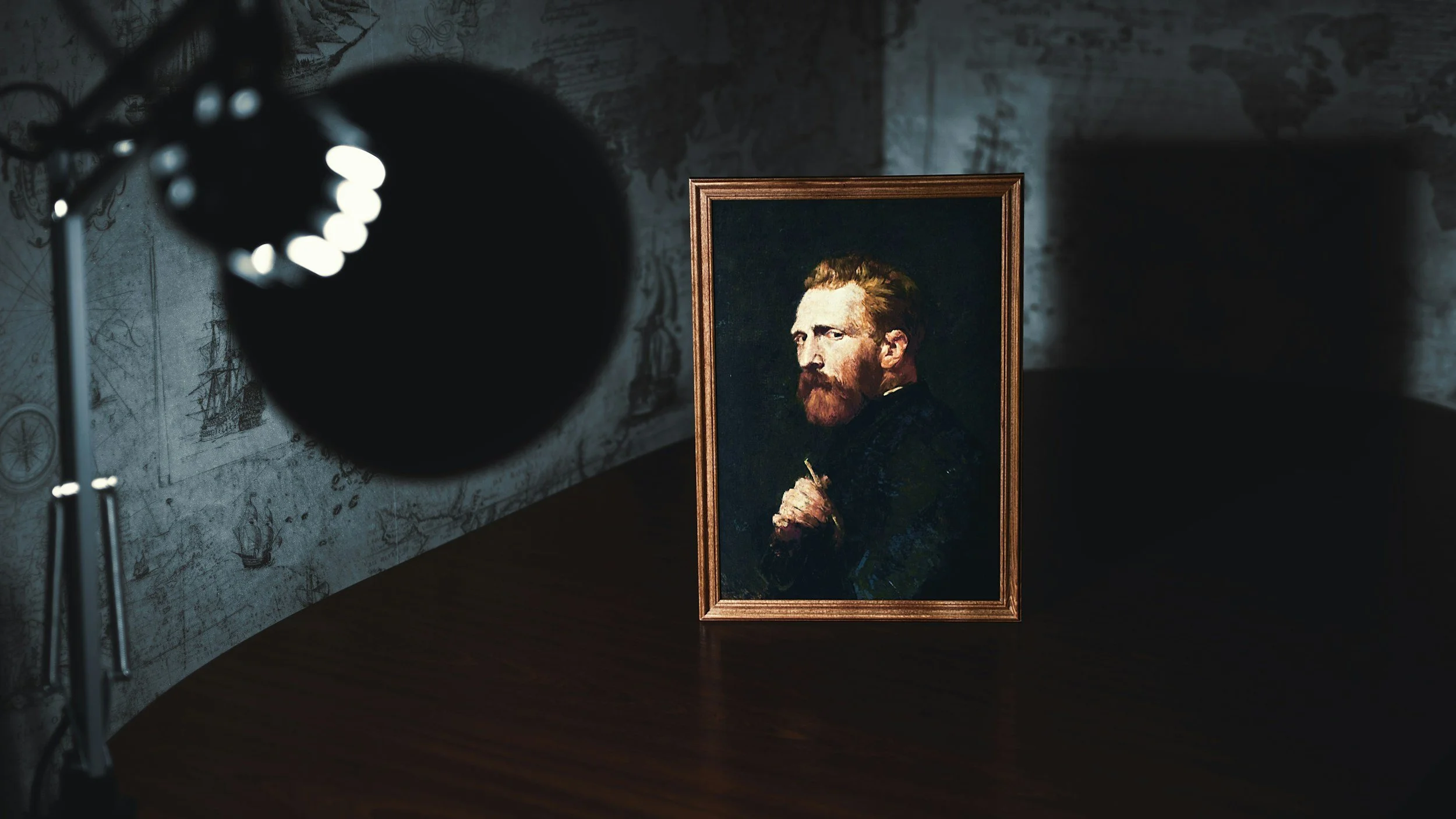 A framed portrait of a man with reddish hair and beard, dressed in dark clothing, is placed on a dark wooden surface in a dimly lit room. A spotlight is directed towards the portrait, with part of the light source and its stand visible on the left side of the image. The background features a wall with a map and ship illustrations.