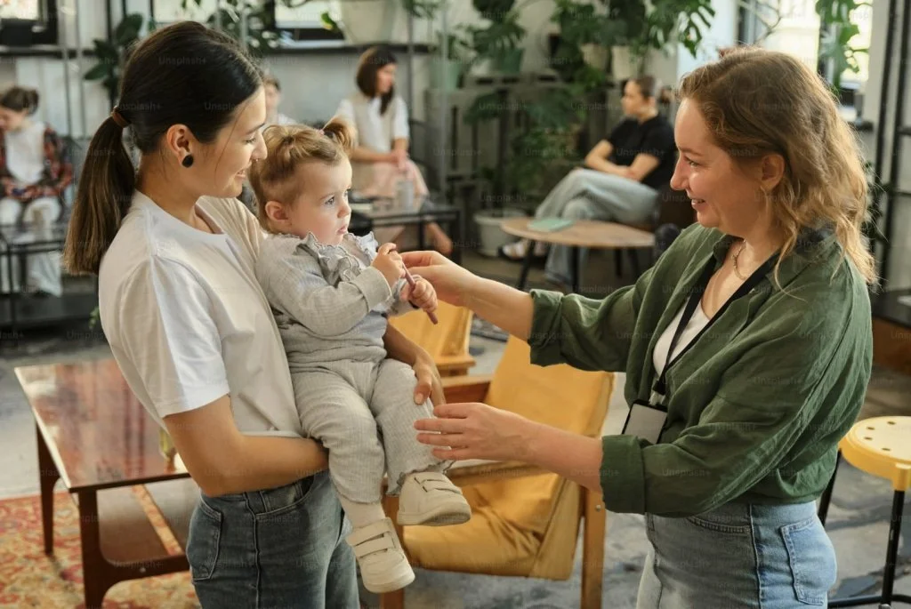 two women, one of them holding a baby