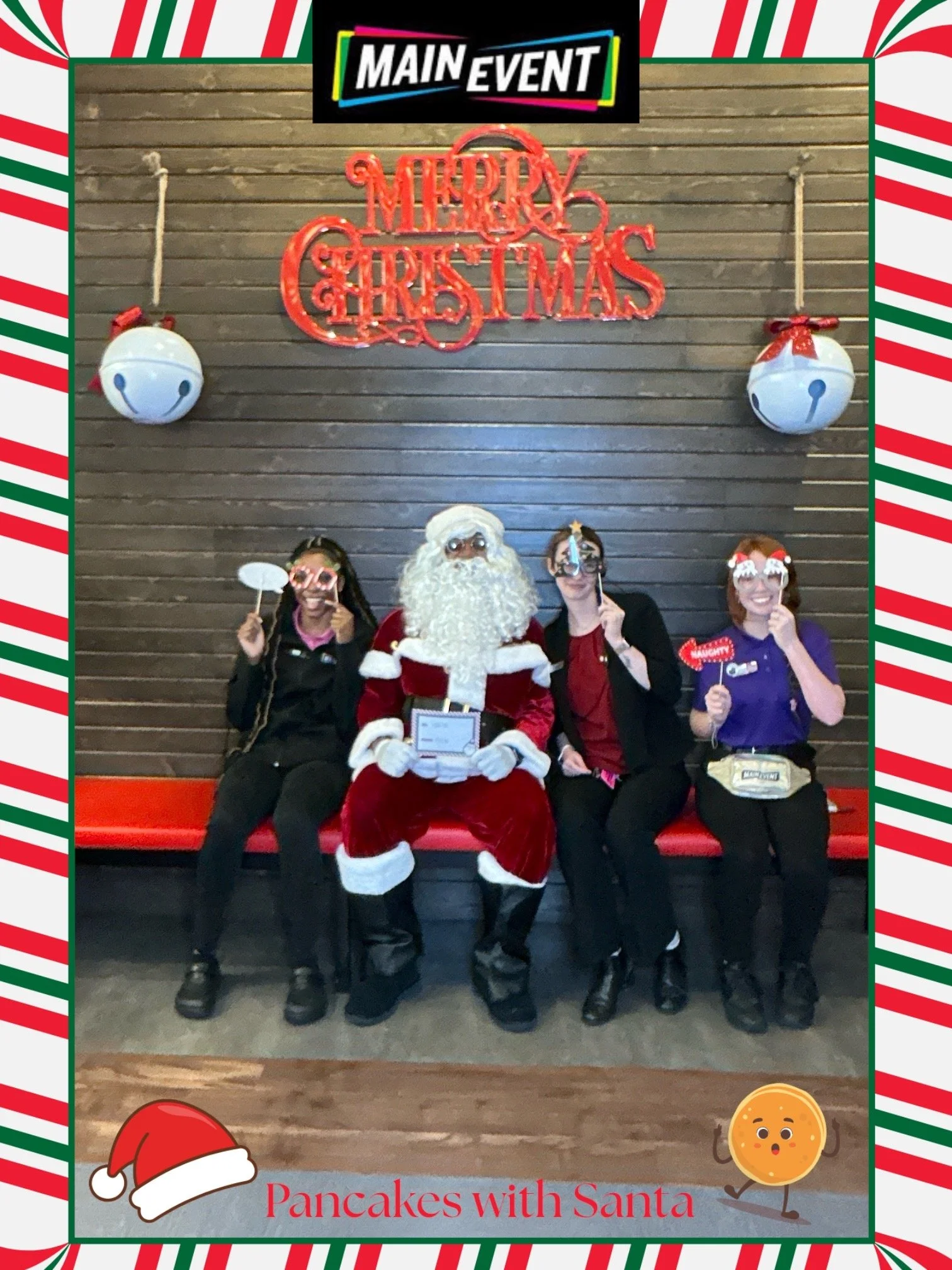 Four women posing with Santa Claus, holding festive photo props, seated on a bench in front of a dark wood wall decorated with a red merry Christmas sign and large white Christmas ornaments. The image has a holiday frame with Santa hat and cookie illustrations, with the text "Pancakes with Santa".