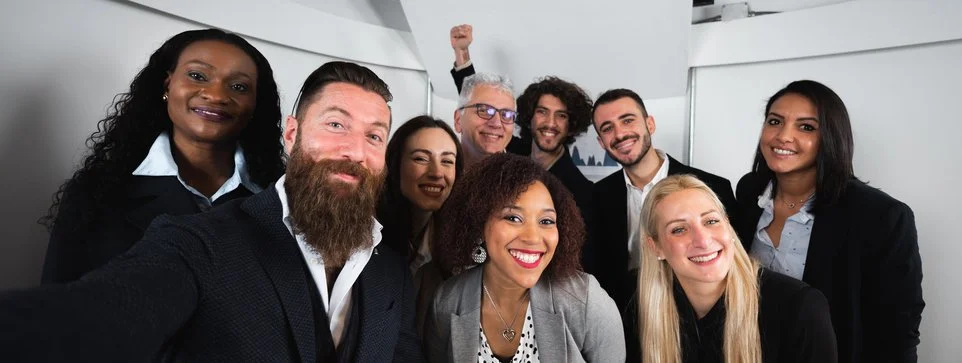 Group of nine diverse professionals smiling in an office