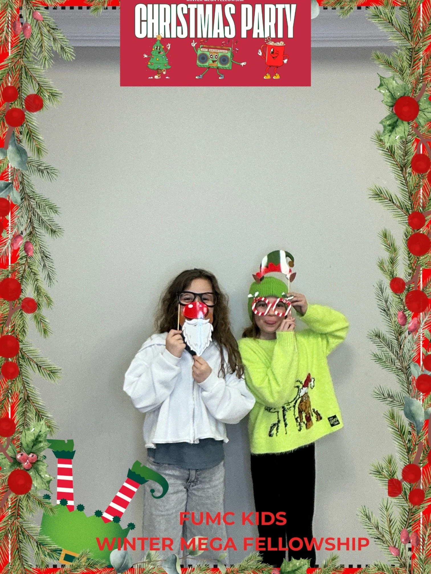Two children wearing Christmas-themed masks and glasses, standing inside a decorated frame with a Christmas party banner above. The girl on the left is holding a Santa beard mask, and the girl on the right is wearing an elf hat and candy cane glasses. The frame is decorated with pine branches, red ornaments, and stockings. Text on the frame reads "FUMC KIDS WINTER MEGA FELLOWSHIP".