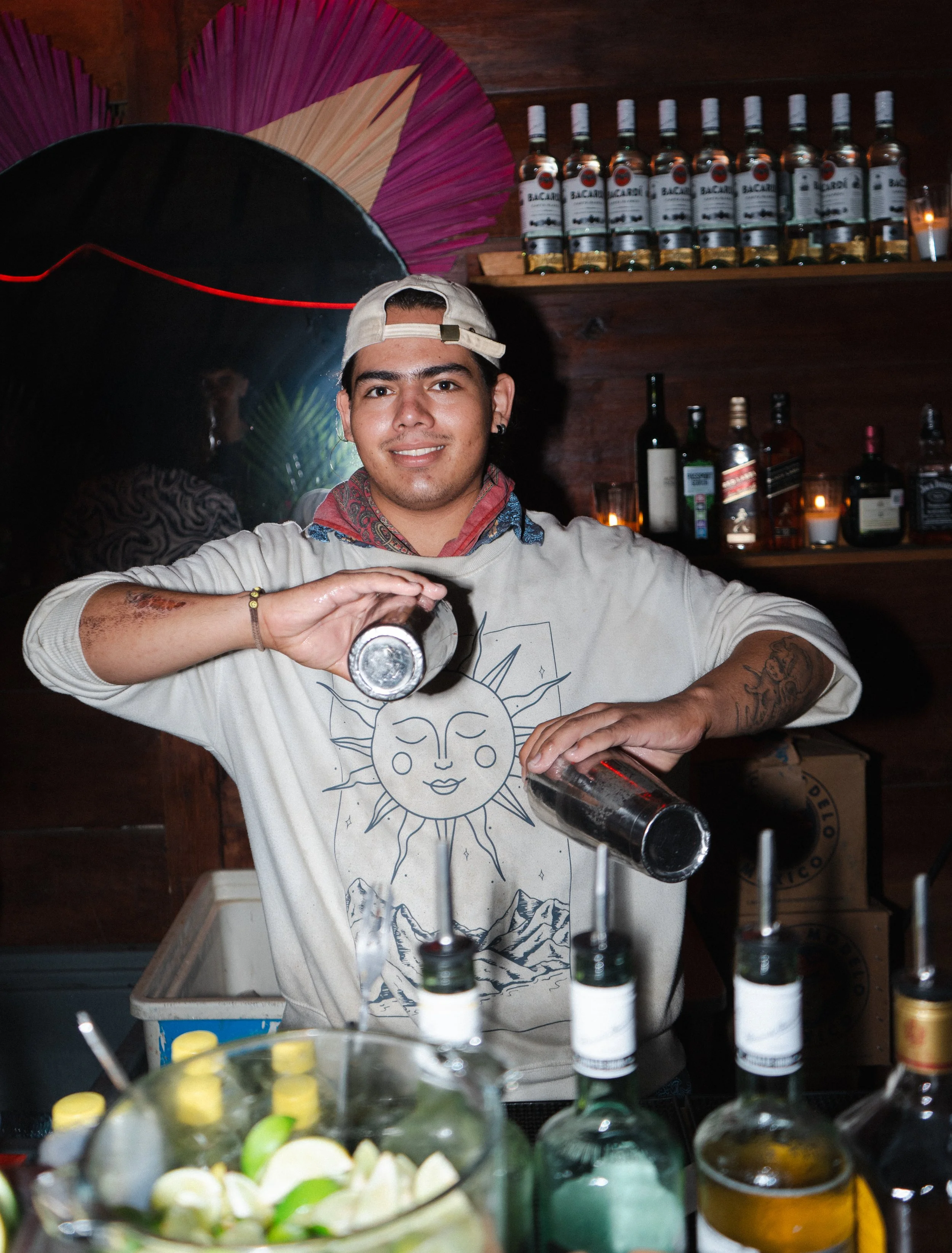 Bartender pouring drinks behind the bar with bottles and decor in background, hospitality and event photography