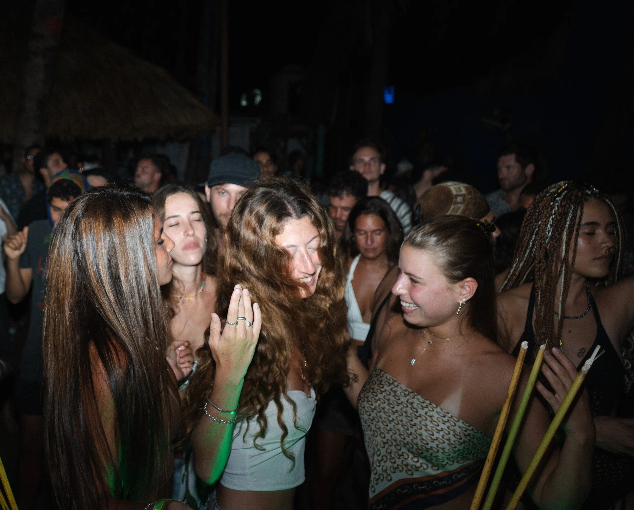Event photography of a group of young women dancing and socializing at a nighttime outdoor event