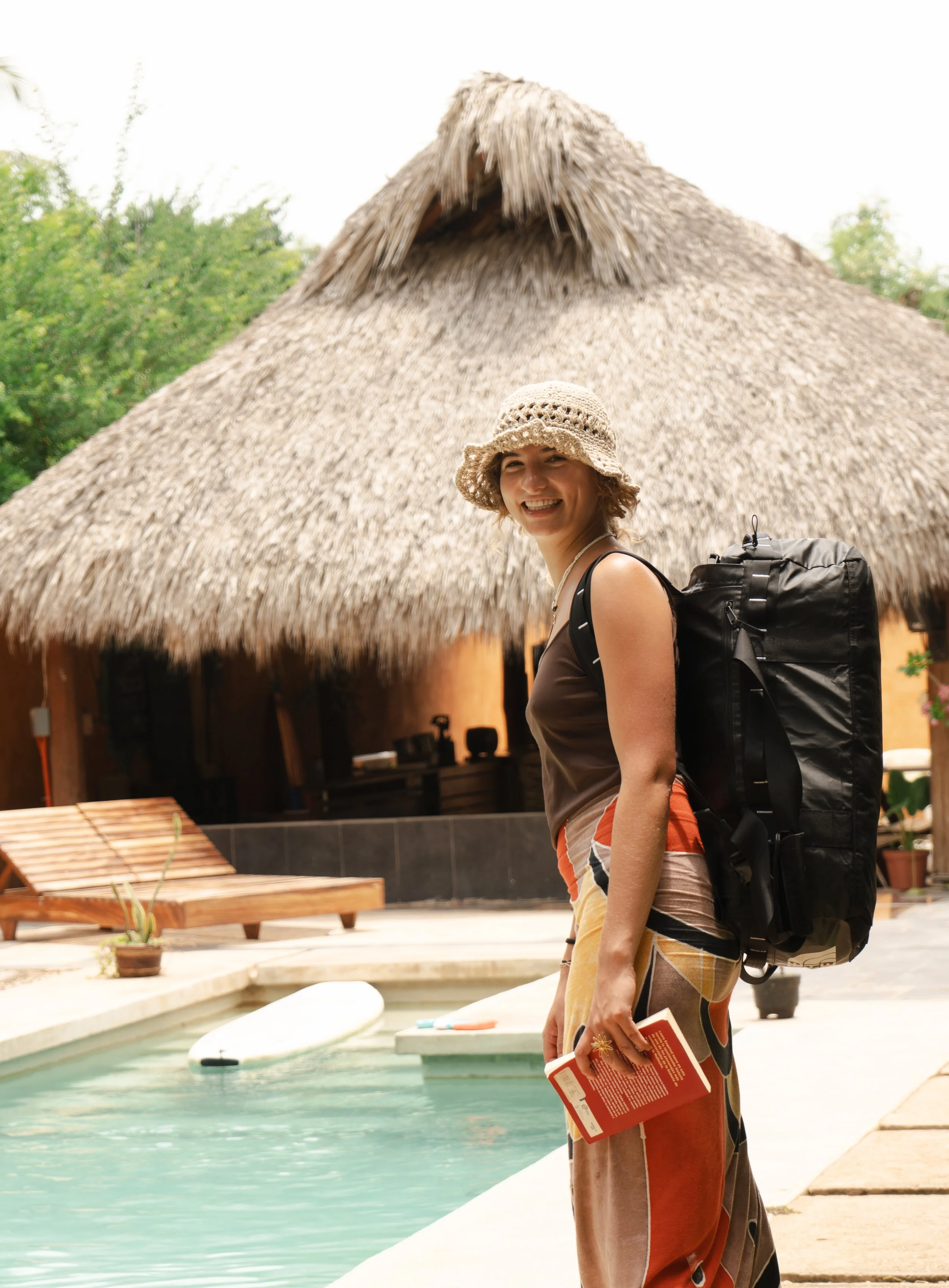 Luxury travel and resort lifestyle photography of woman standing poolside with tropical villa backdrop