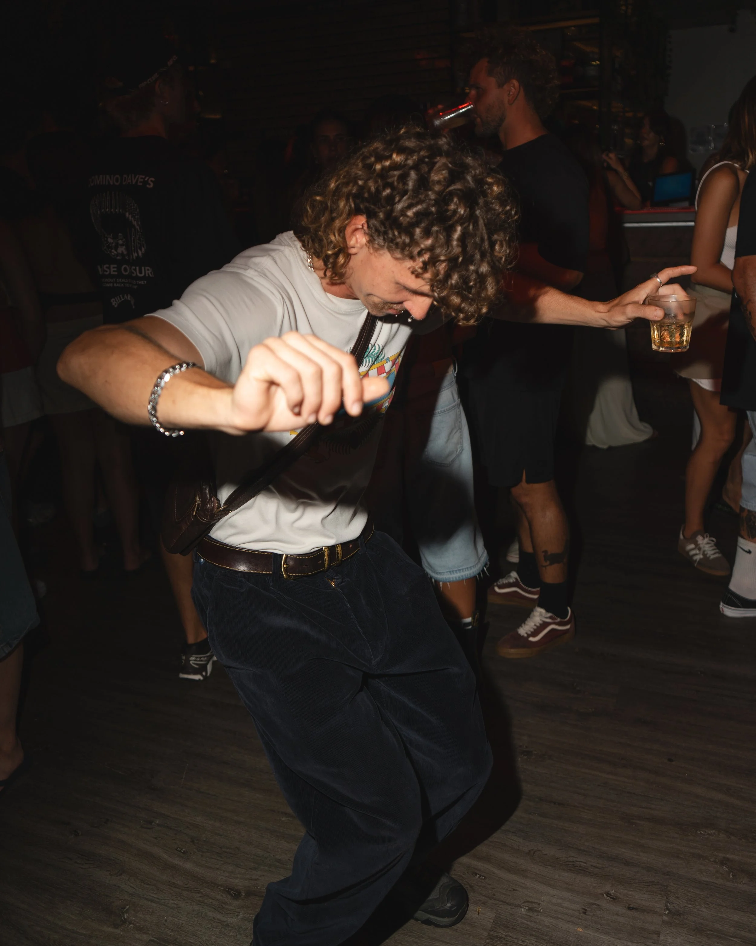 Person dancing at a crowded indoor party in Noosa with people holding drinks in the background, Sunshine Coast event and nightlife photography