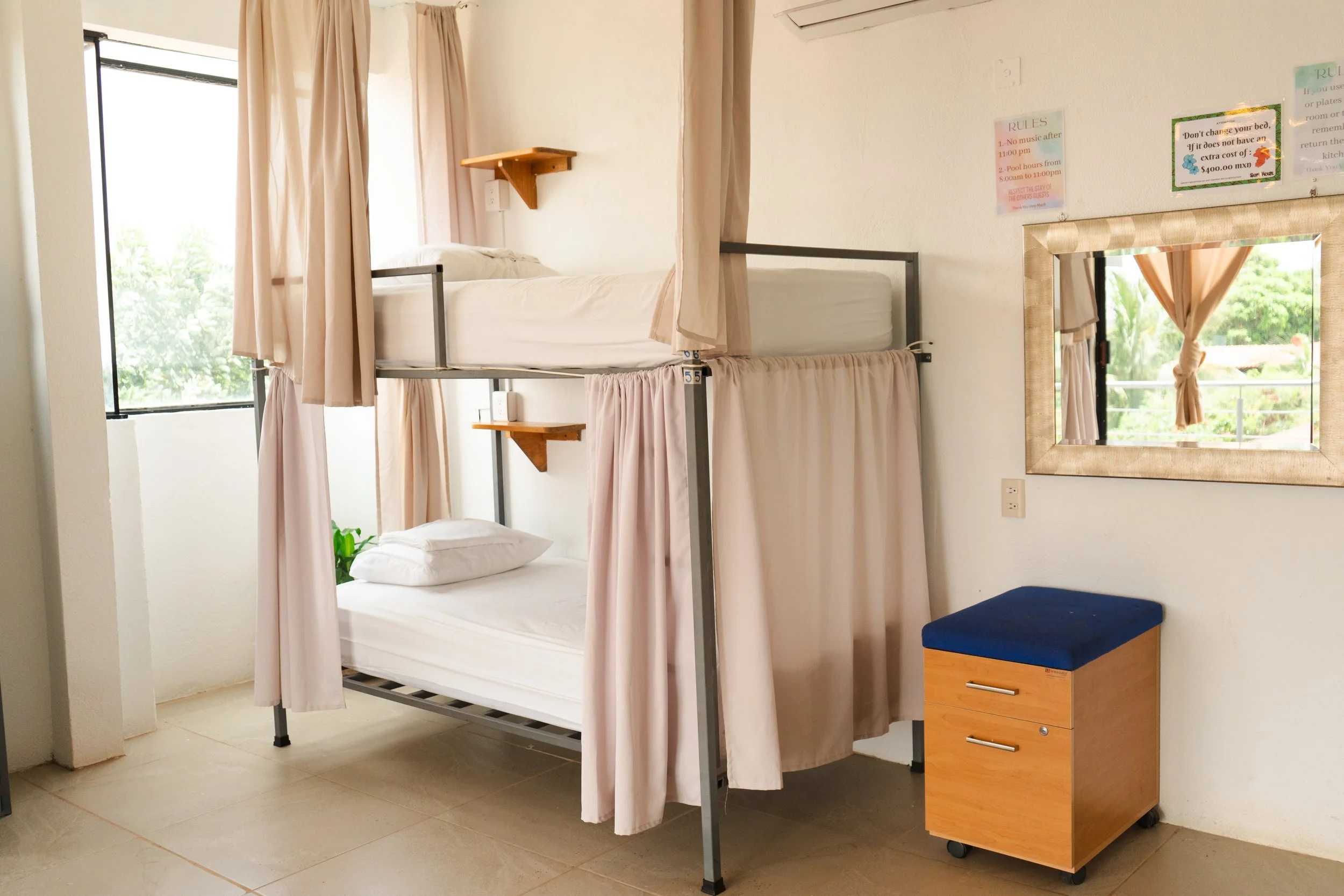 Hospitality interior photography of boutique bunk room with privacy curtains and minimalist styling