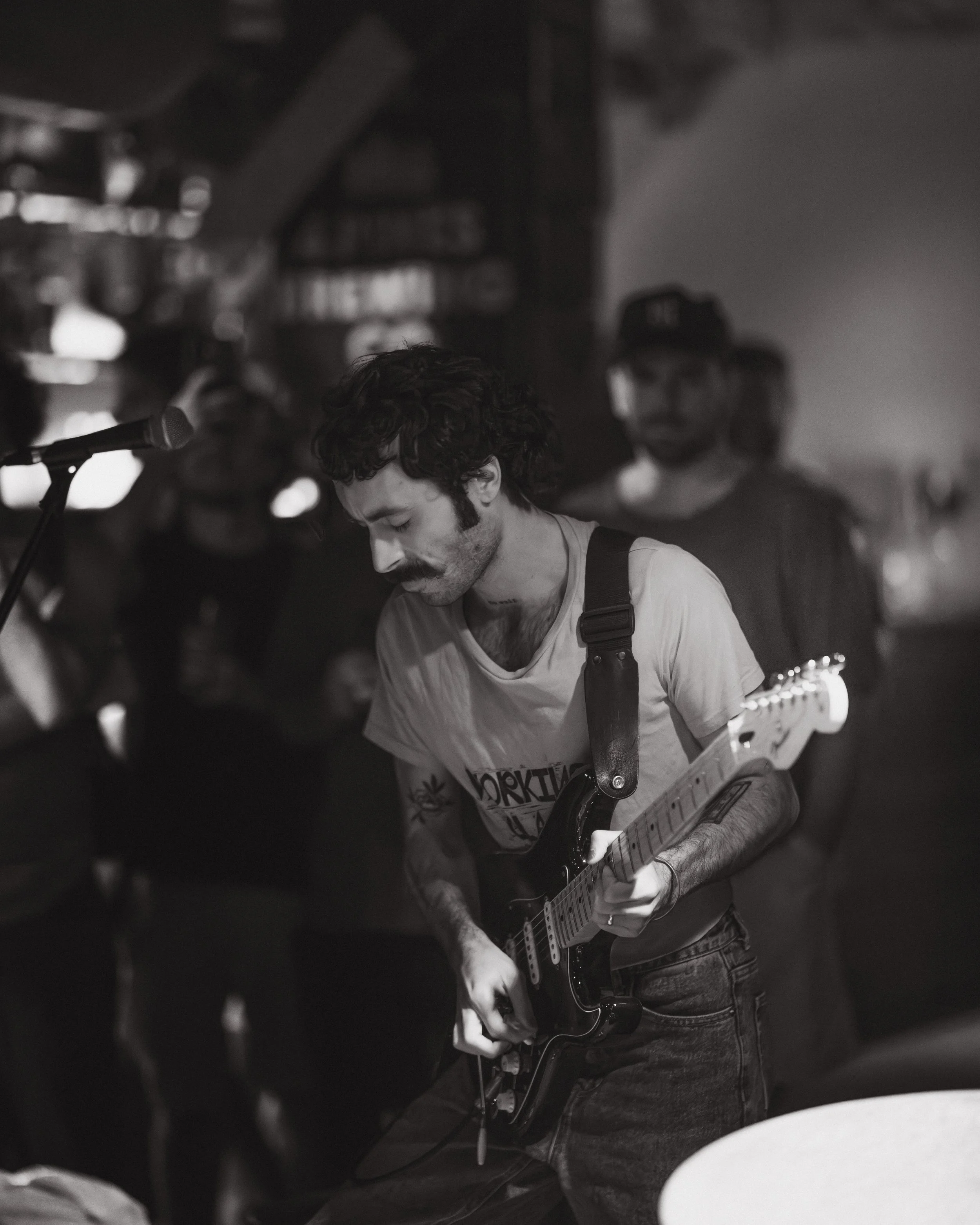 Live music photography of a guitarist performing on stage at a Noosa bar. 