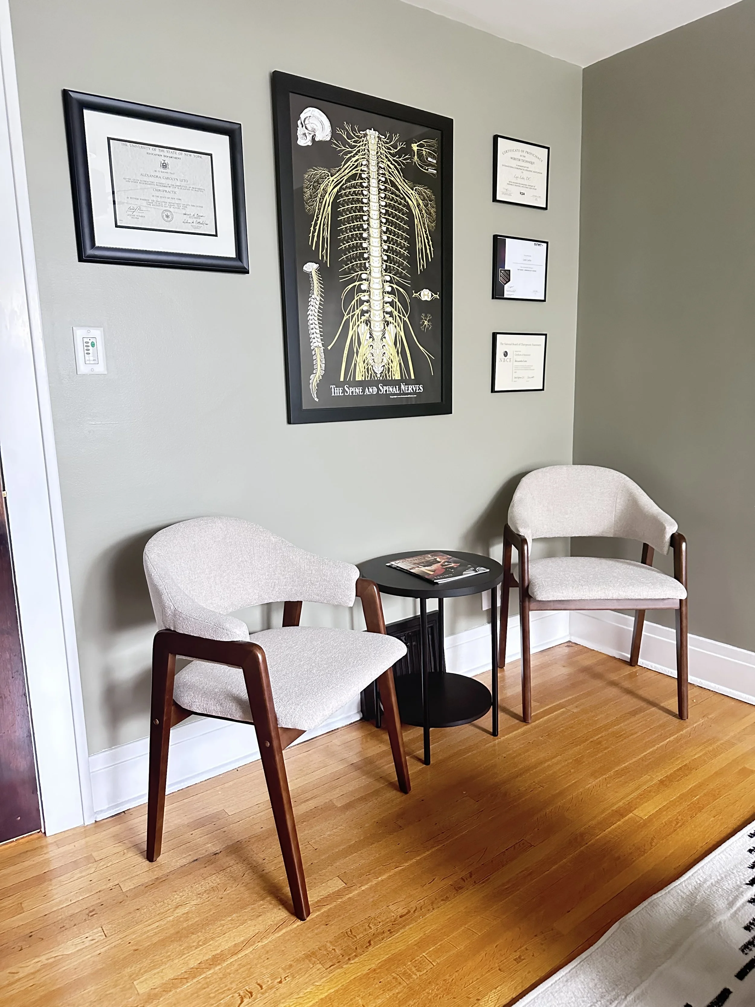 Chiropractic office waiting area in Batavia NY with seating and spine/nervous system artwork