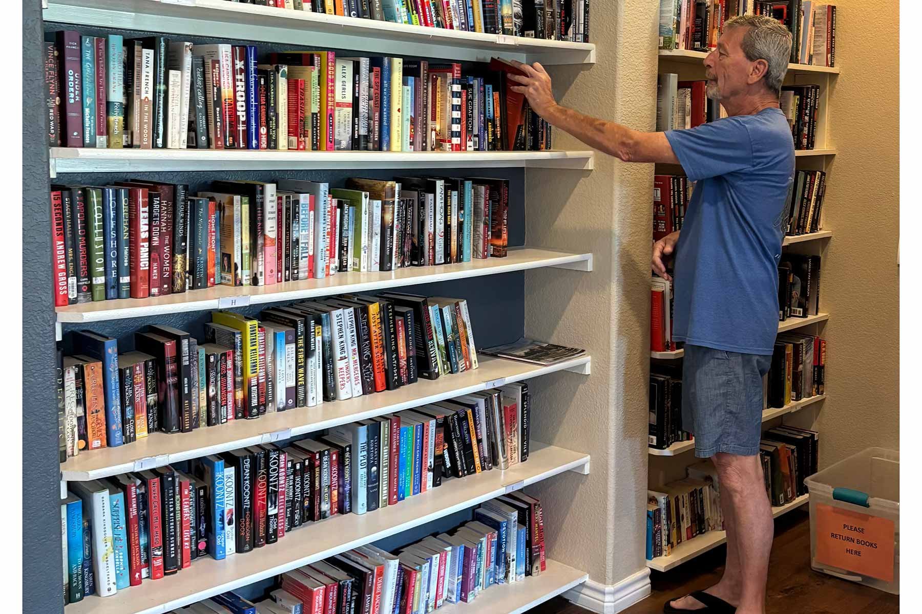 man-selecting-book-in-library-at-clubhouse