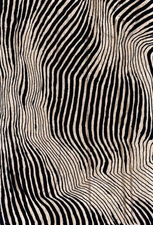 Close-up of a fabric with black and white wavy striped pattern creating an optical illusion.