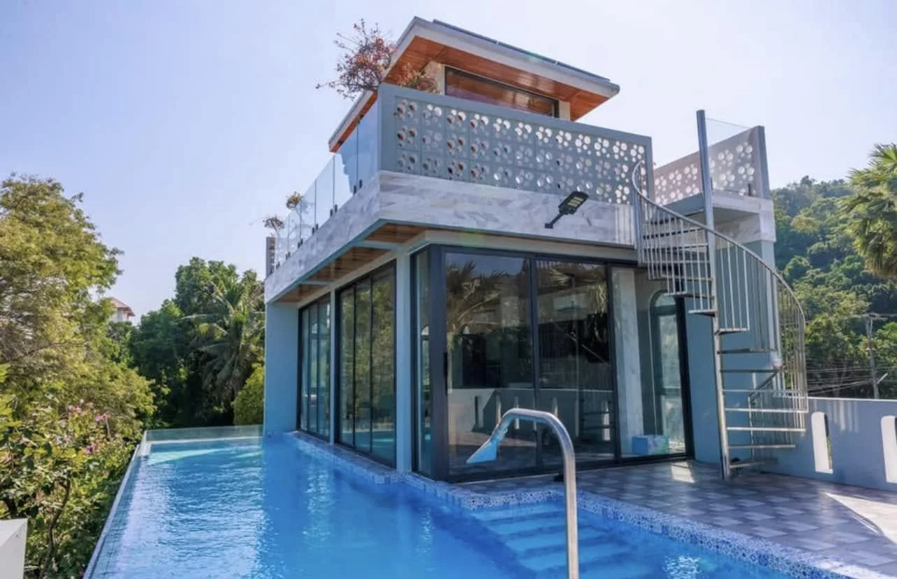 Outdoor Entertaining: A view from the pool deck showcasing the villa’s extensive use of glass and metal.