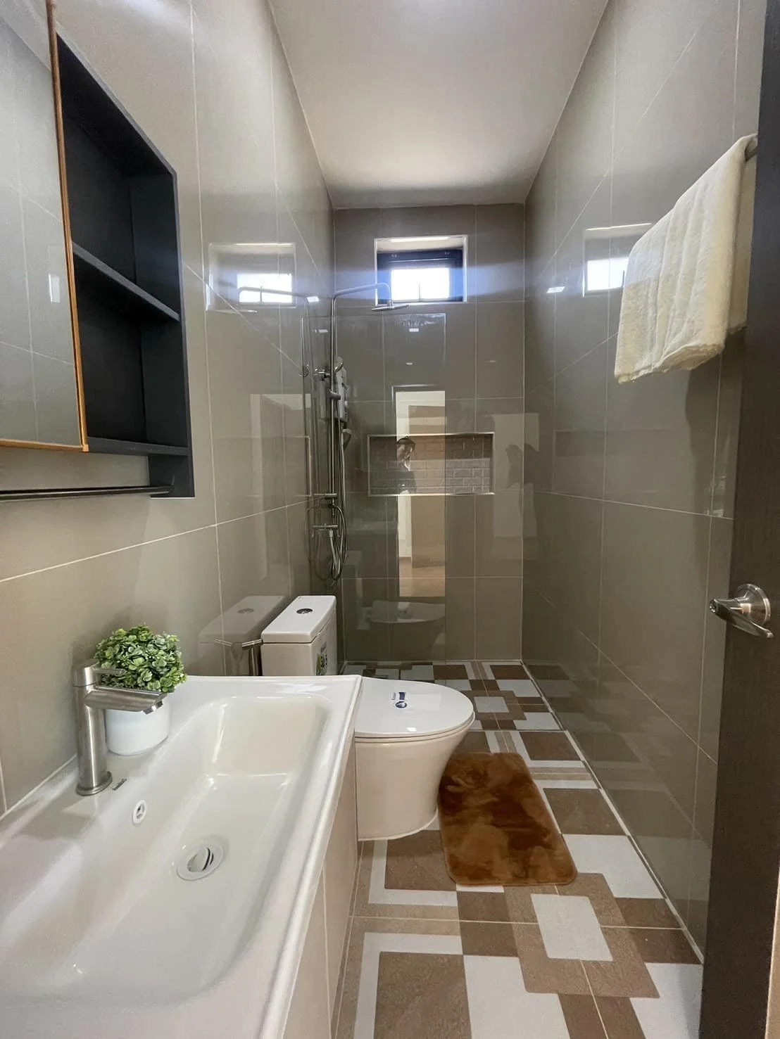 A pristine, modern bathroom showcasing elegant fixtures, a rainfall shower, and designer tiled flooring that reflects the villa's high-quality finish.