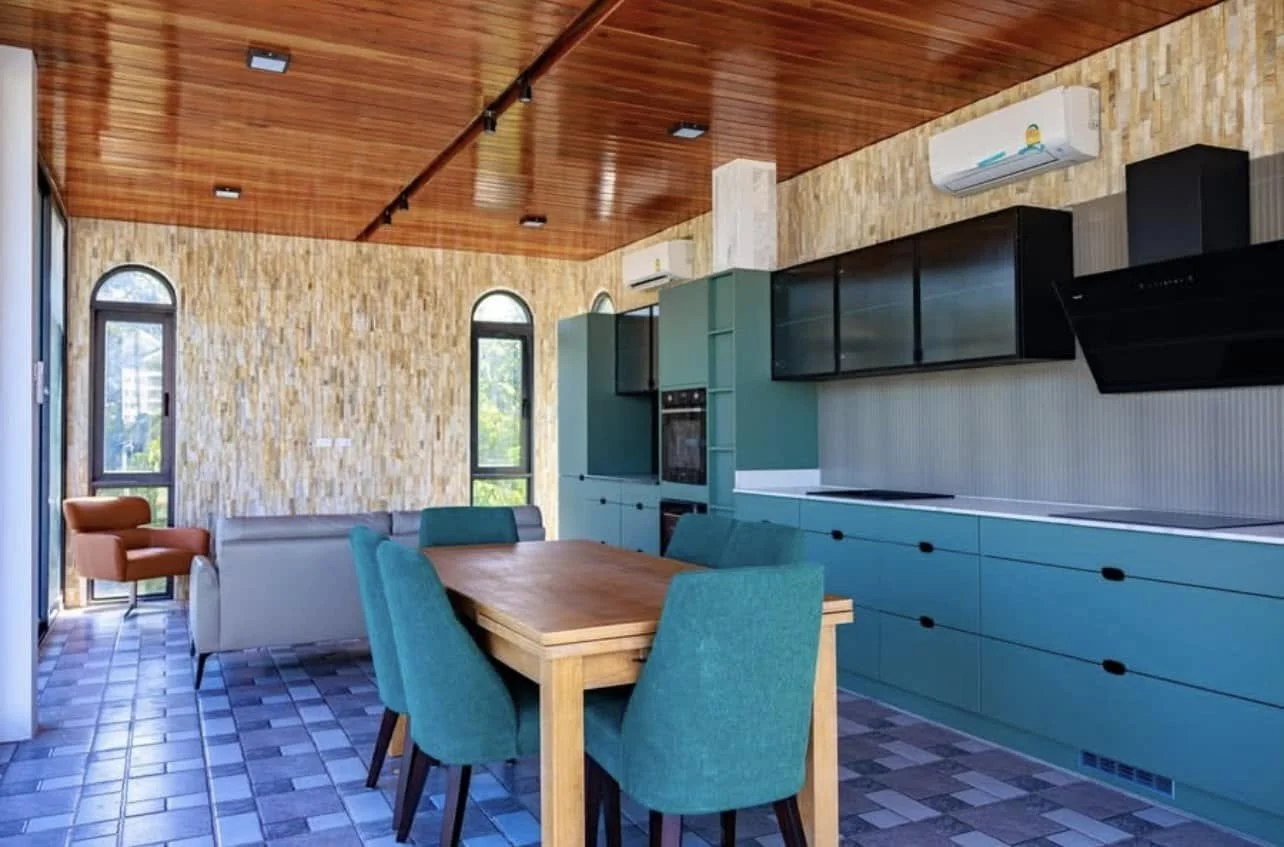 Contemporary Culinary Hub: A vibrant, petrol-blue designer kitchen featuring minimalist cabinetry and integrated high-end appliances.