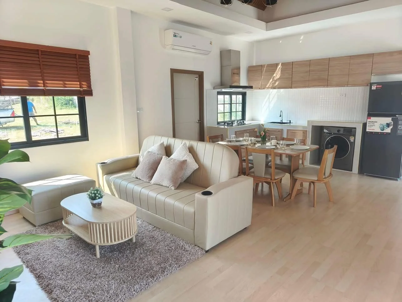 A seamless transition from the comfortable living area to a compact, modern kitchen equipped with integrated appliances.