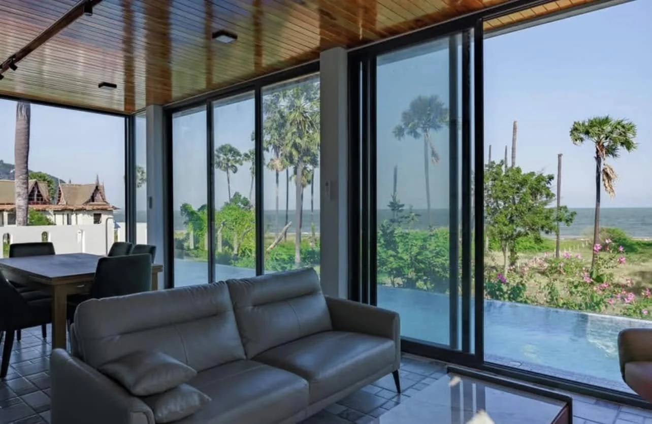 Living Area: Panoramic coastal tableau of swaying tropical palms and the shimmering Gulf of Thailand