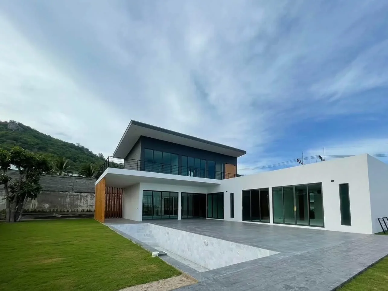 High-perspective view of the 12.5-meter lap pool and the minimalist white exterior design of this luxury Hua Hin investment.