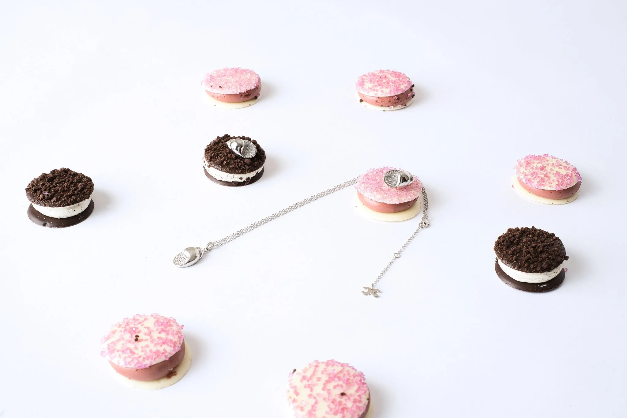 Assorted cookies and jewelry on a white surface