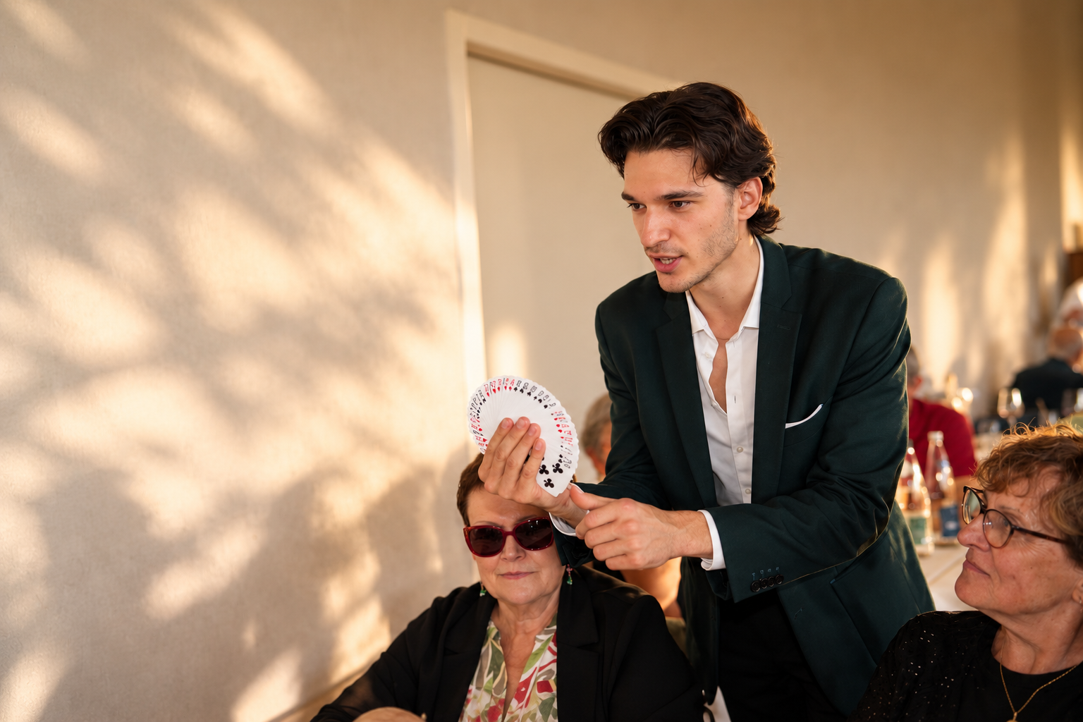 Deux personnes échangent une partie de jeu de cartes, une personne en smoking et une autre en costume, lors d'une cérémonie ou d'un événement formel.