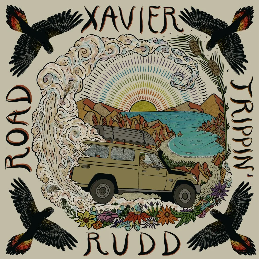 An illustrated album cover for Xavier Rudd's band, featuring a mountain landscape with a sunset, a river, flowers, and four black birds surrounding the scene. A beige vehicle is in the center, with swirling clouds and decorative elements.