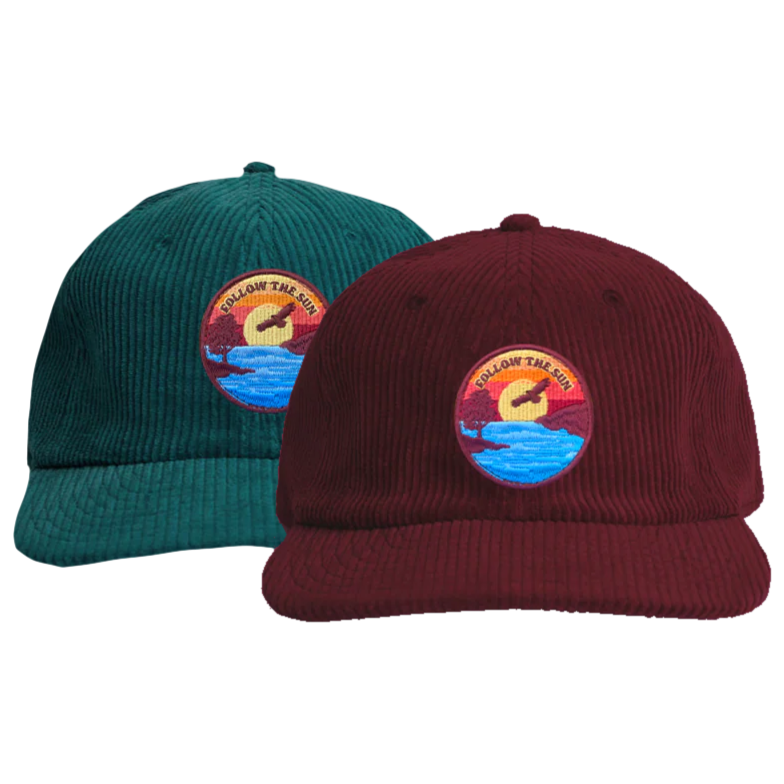 Two corduroy baseball caps, one teal and one maroon, with embroidered patches of a sunset over a lake with the words 'Follow the Sun'.