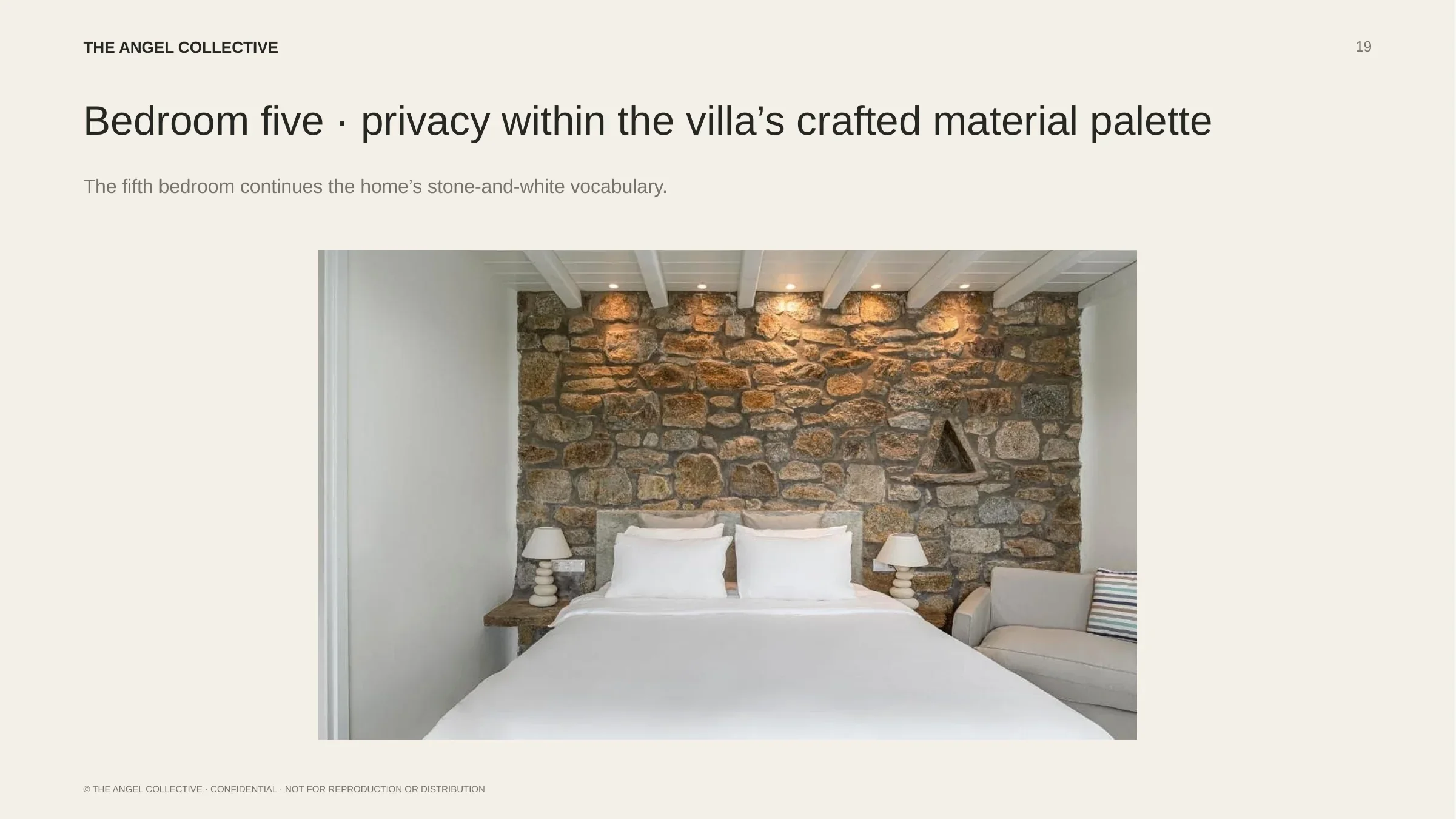 Bedroom five: Private double bedroom featuring a traditional stone wall and understated Cycladic decoration.