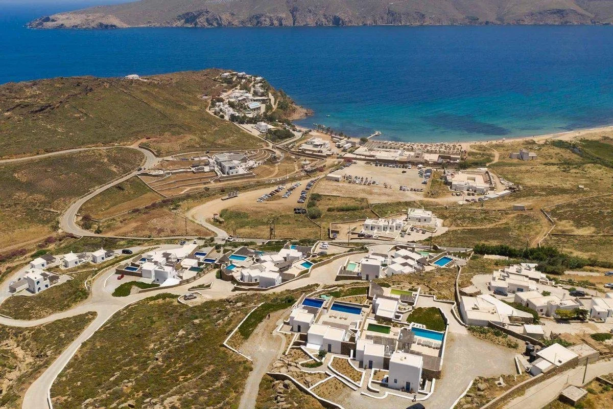Aerial view of villas along the Mykonos coastline surrounded by the Aegean landscape