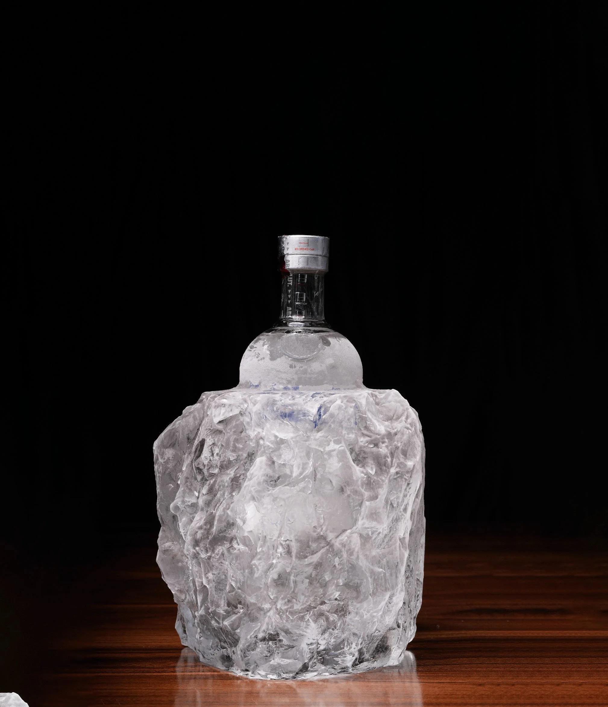 Bespoke clear ice encasements with suspended elements like bottles for luxury presentation