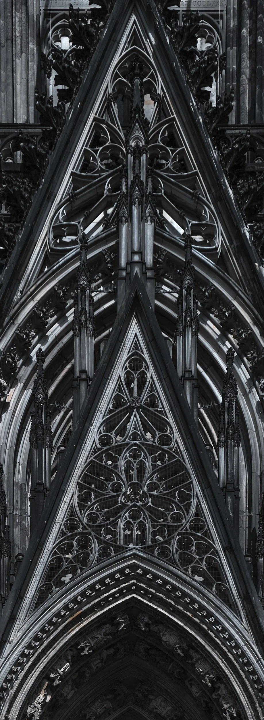 Close-up view of Gothic cathedral architecture with pointed arches, intricate stone carvings, and stained glass windows.