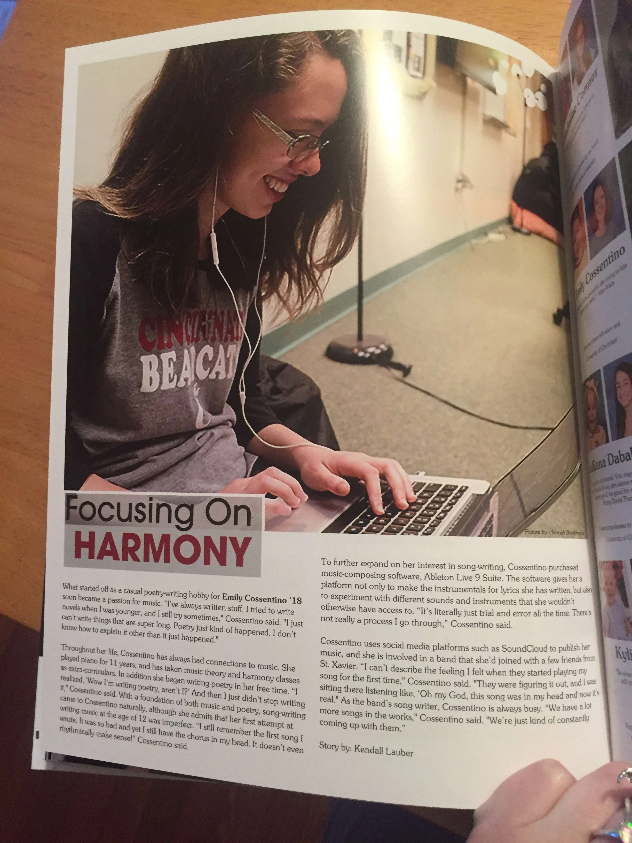 Emily is pictured in a featured article from her high school yearbook about how she produces her own music. She is smiling and wearing a Cincinnati Bearcats shirt.