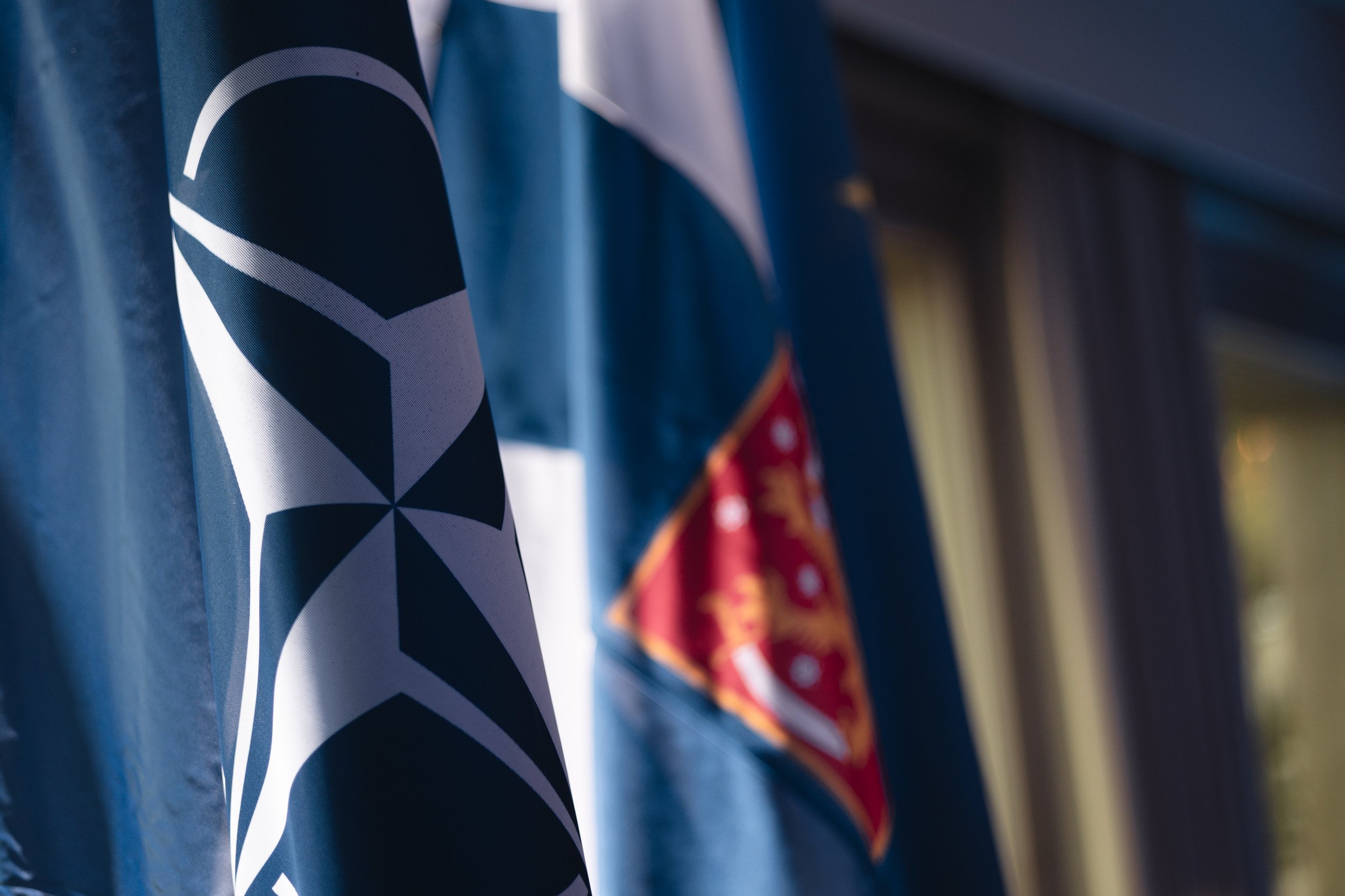 Close-up of flags, one showing the Pittsburgh Steelers logo and another background flag with red and gold colors.