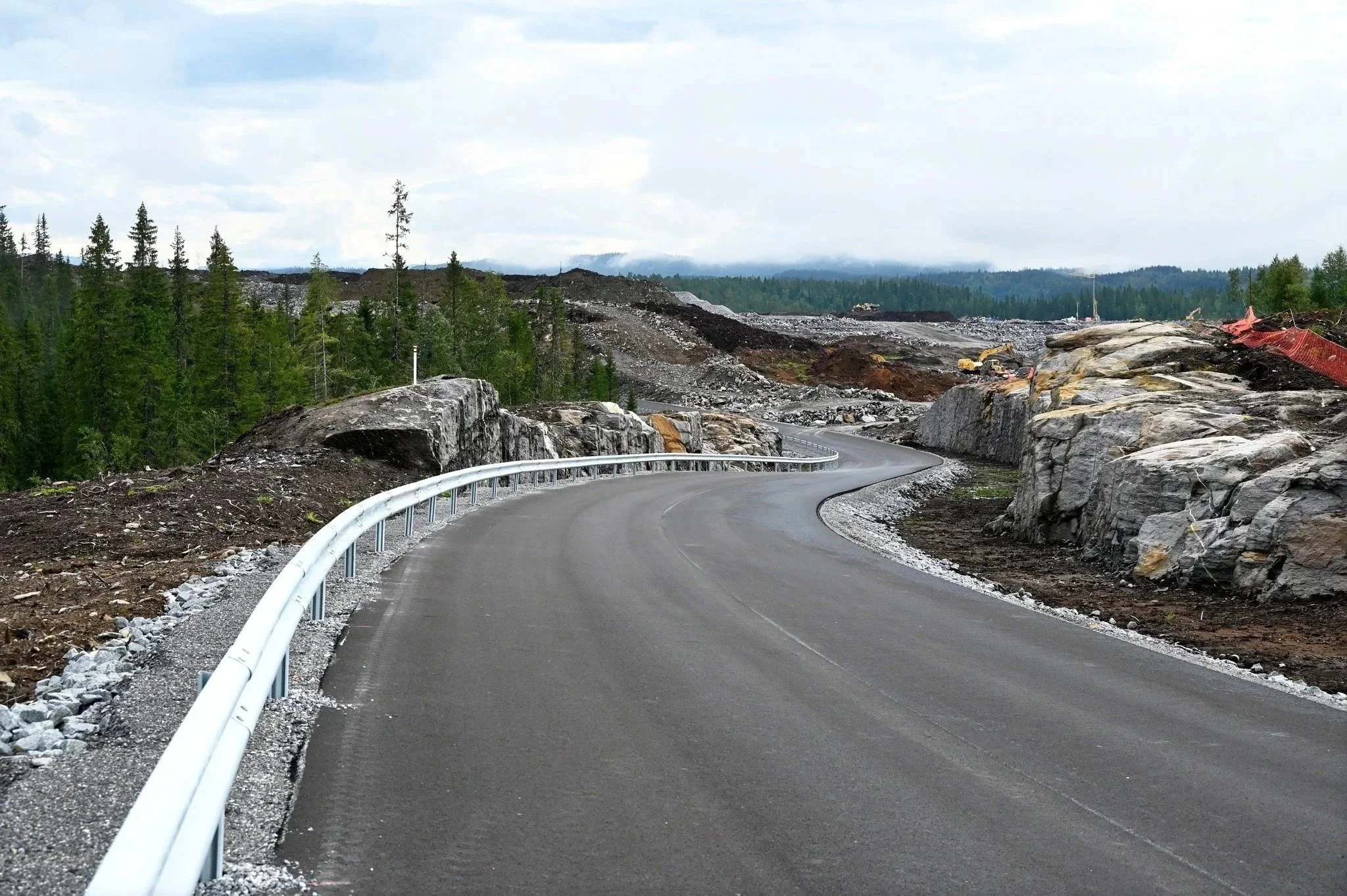 Svingete vei som går gjennom et skogområde med utgravinger og bygging av vei.