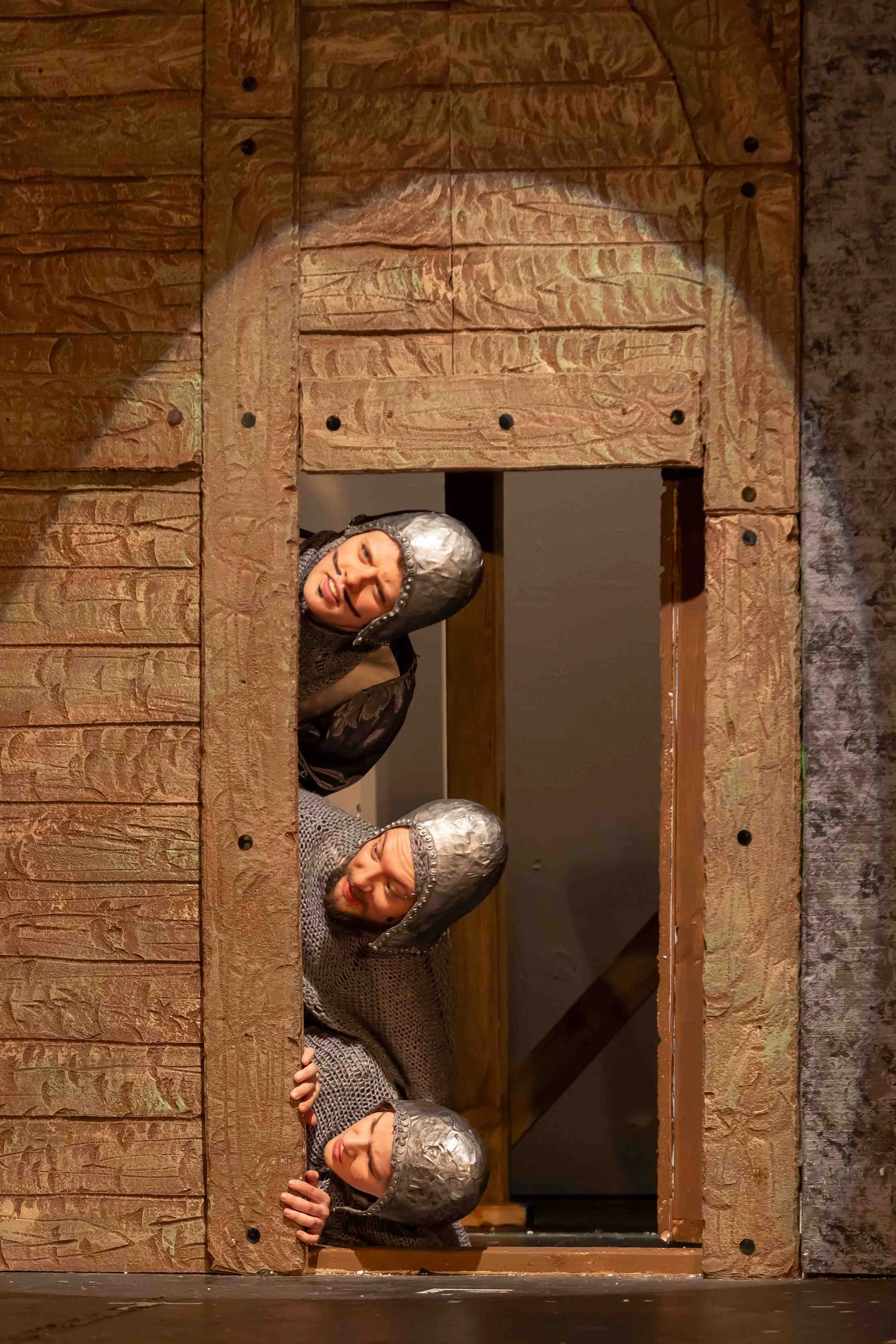 French taunters from Spamalot musical peeking through a castle door.