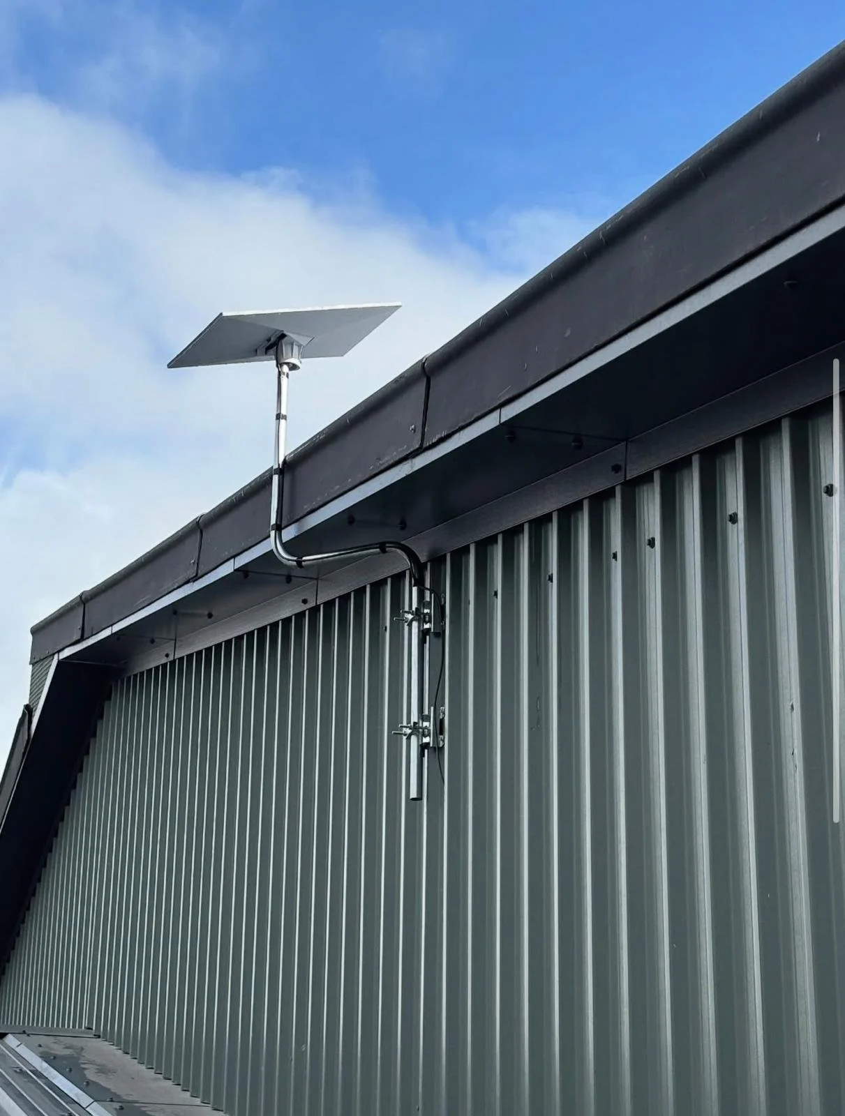 close up view of a Starlink installation on a metal cladded building.