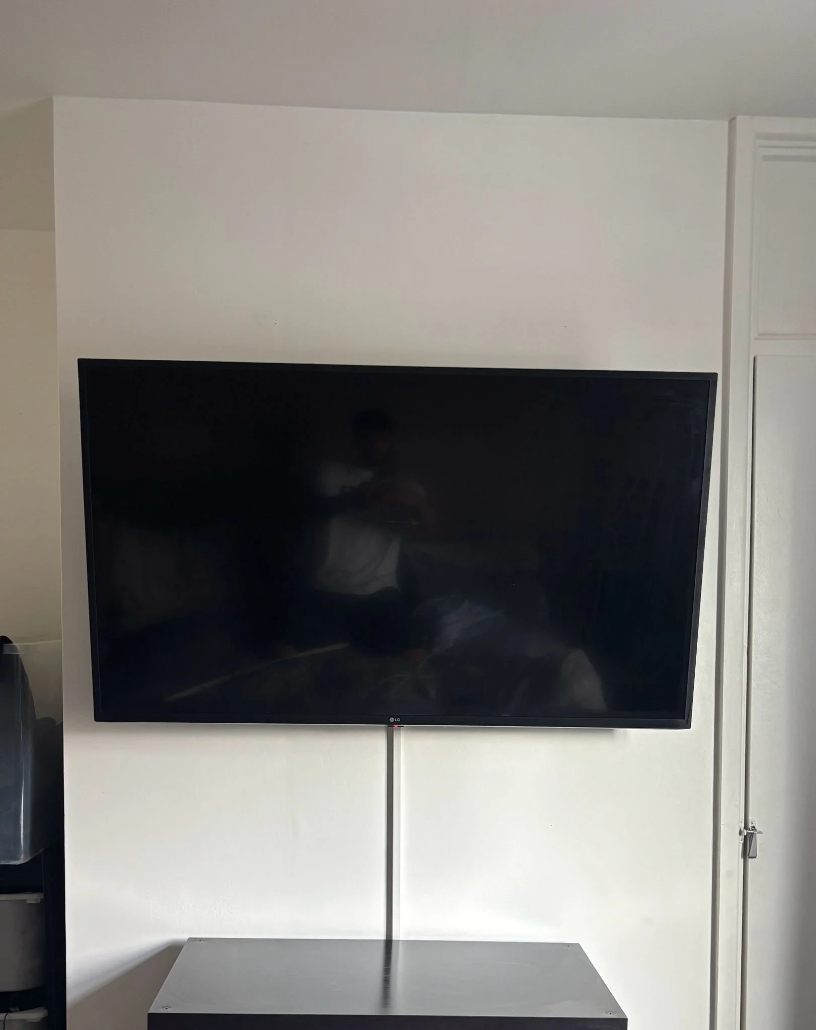 A large flat-screen television mounted on a white wall.