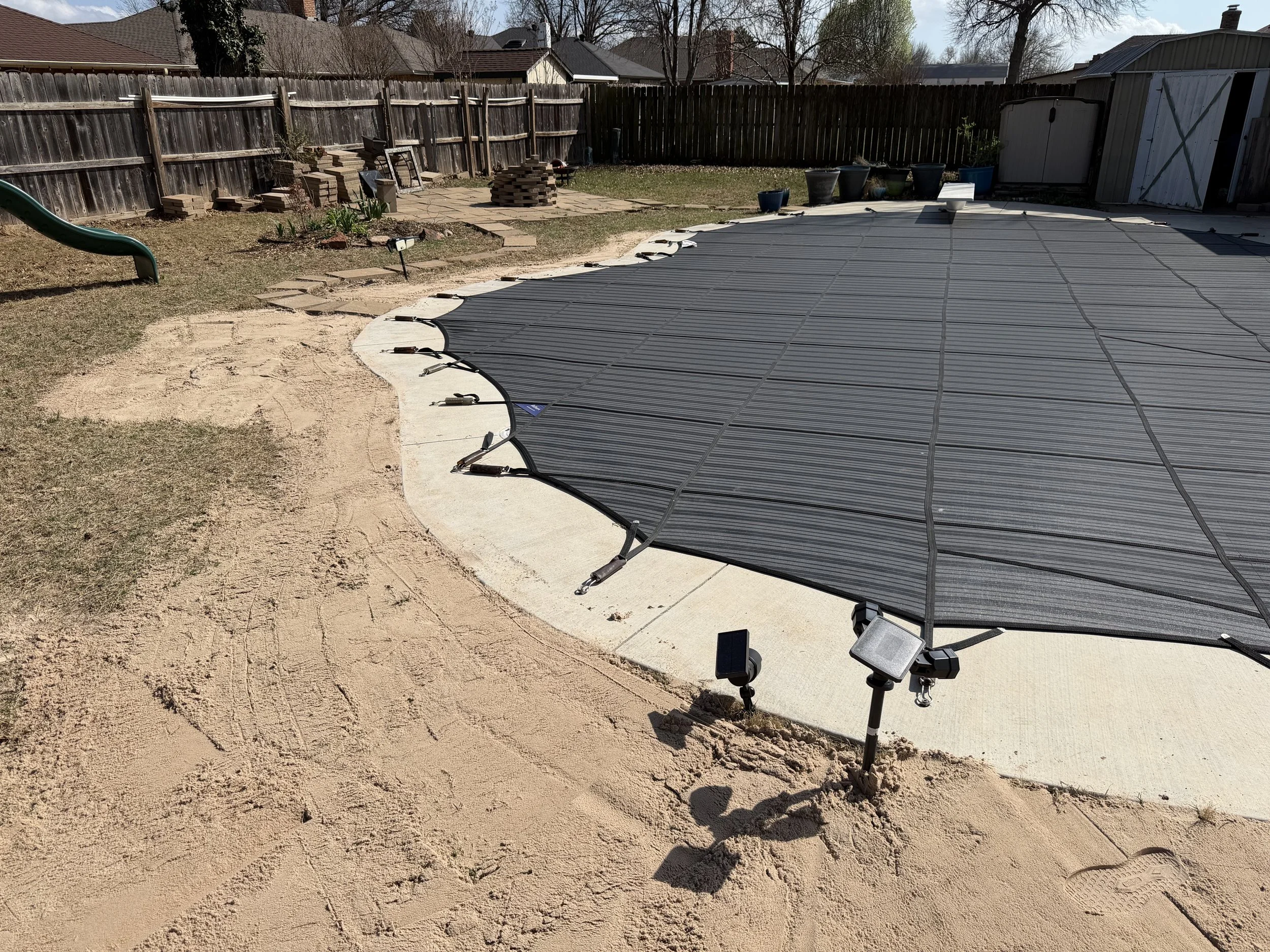 Spread sand to level the lawn next to the pool