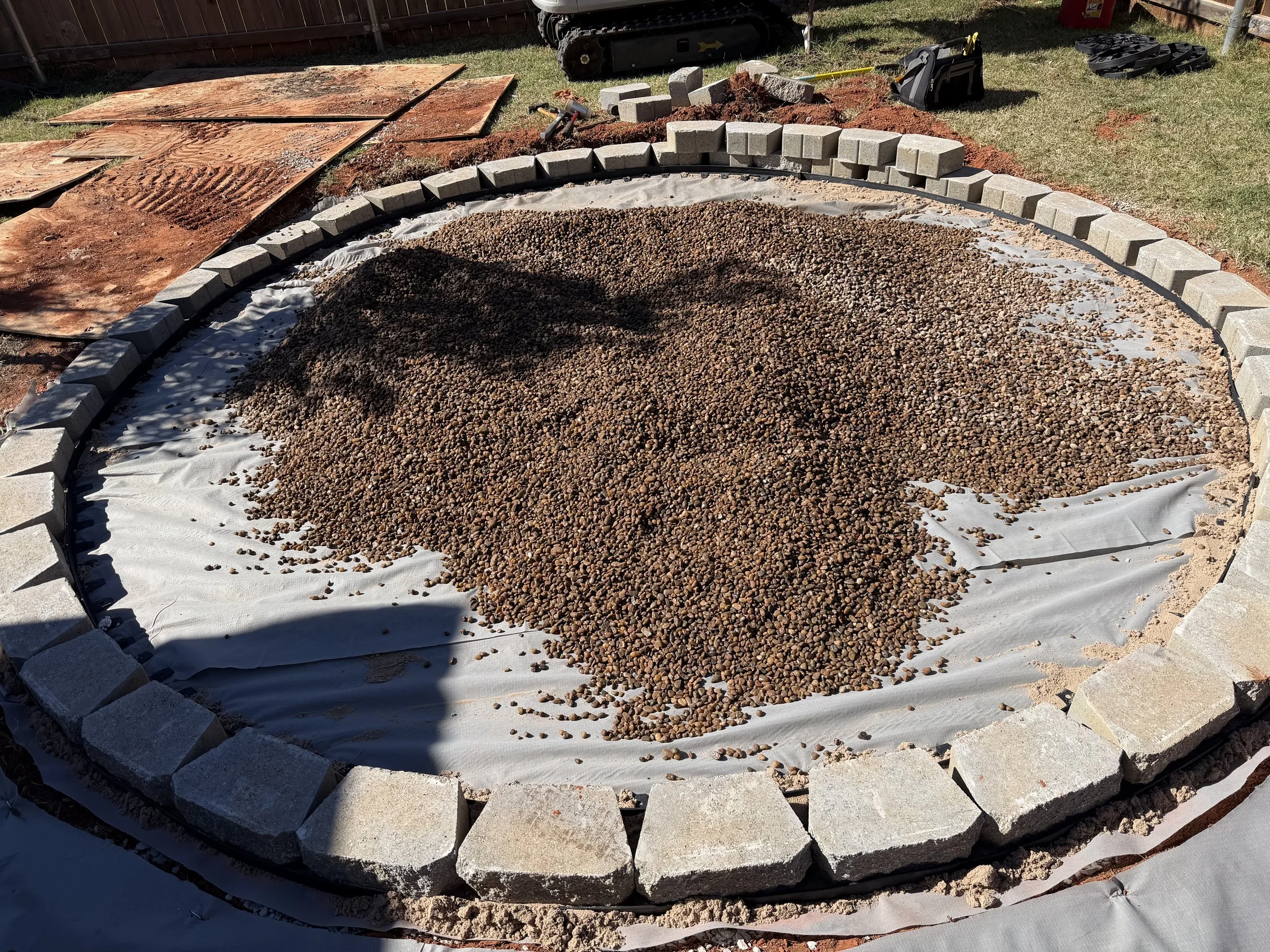 Putting in the river rock to finish the firepit