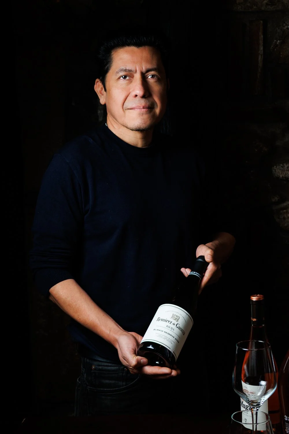 Retrato profesional de sumiller con botella de vino para restaurante o bodega