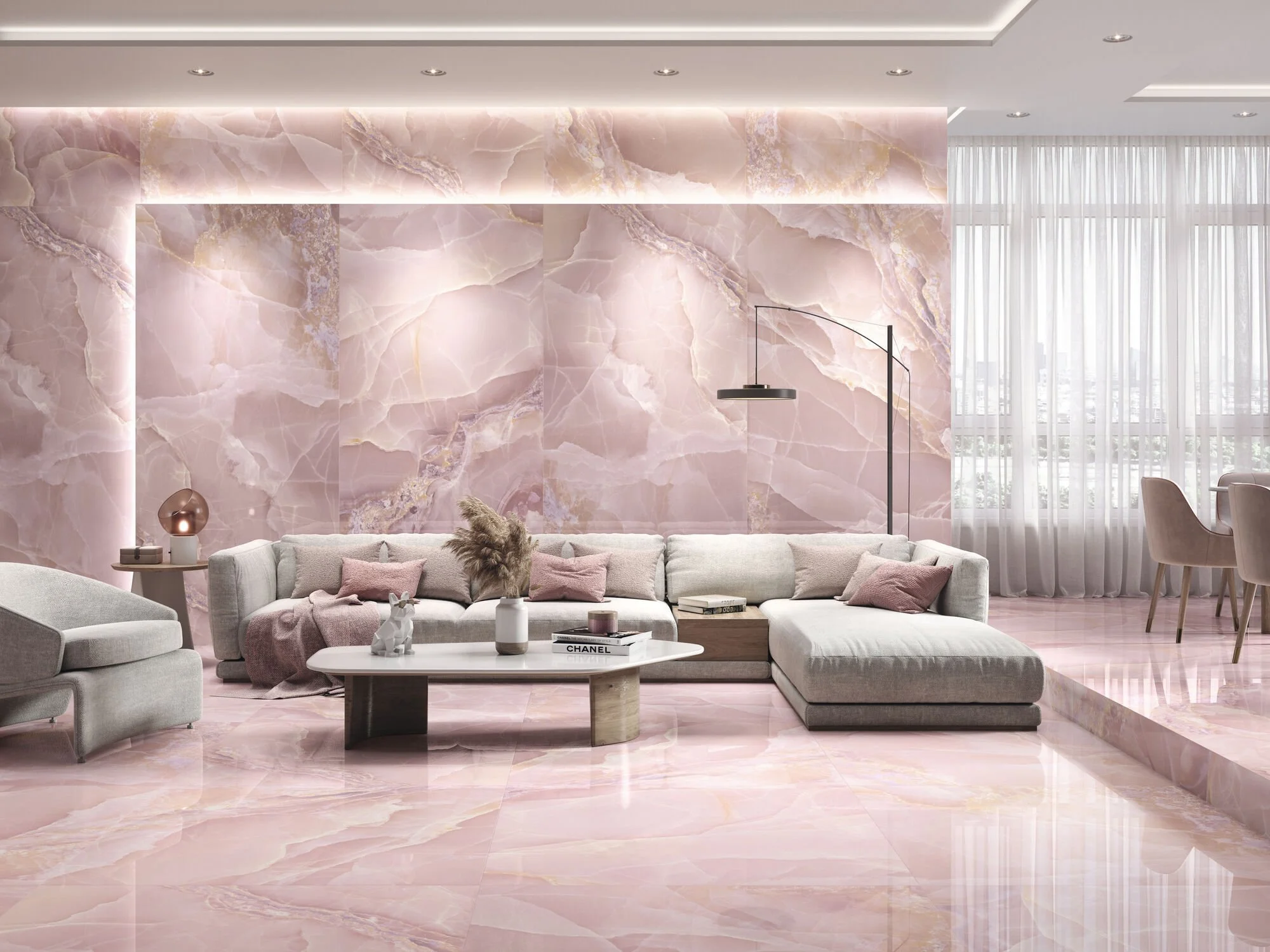 Salon élégant avec murs en marbre rose pâle, un canapé gris clair, table basse blanche, lampes décoratives et grandes fenêtres avec rideaux blancs