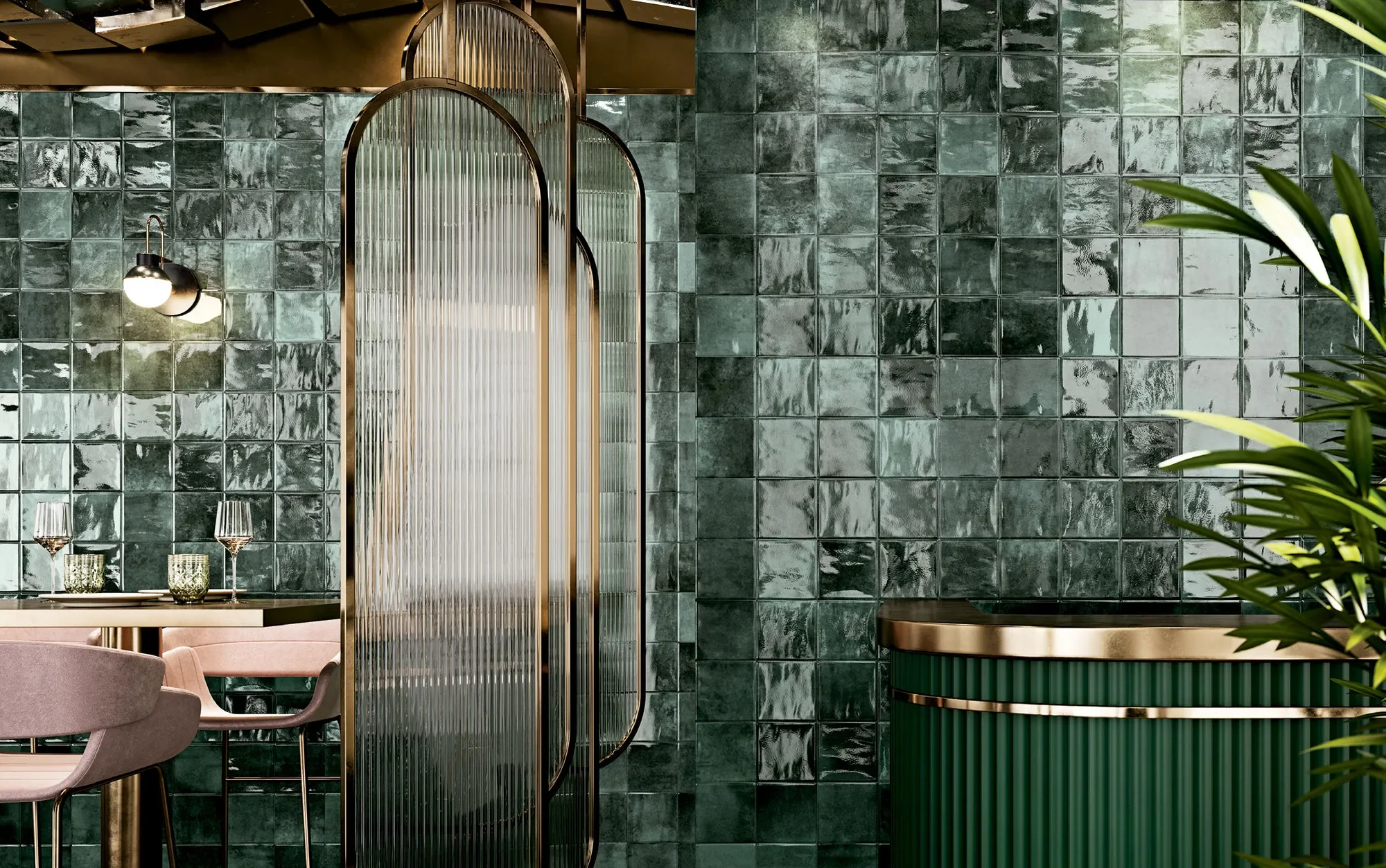 Intérieur d'un restaurant ou d'un café avec un mur en carreaux verts, une salle à manger avec une table, des chaises et des verres, une lumière suspendue et une séparation en verre avec des cadres en métal doré, et un meuble en vert avec des détails en or.