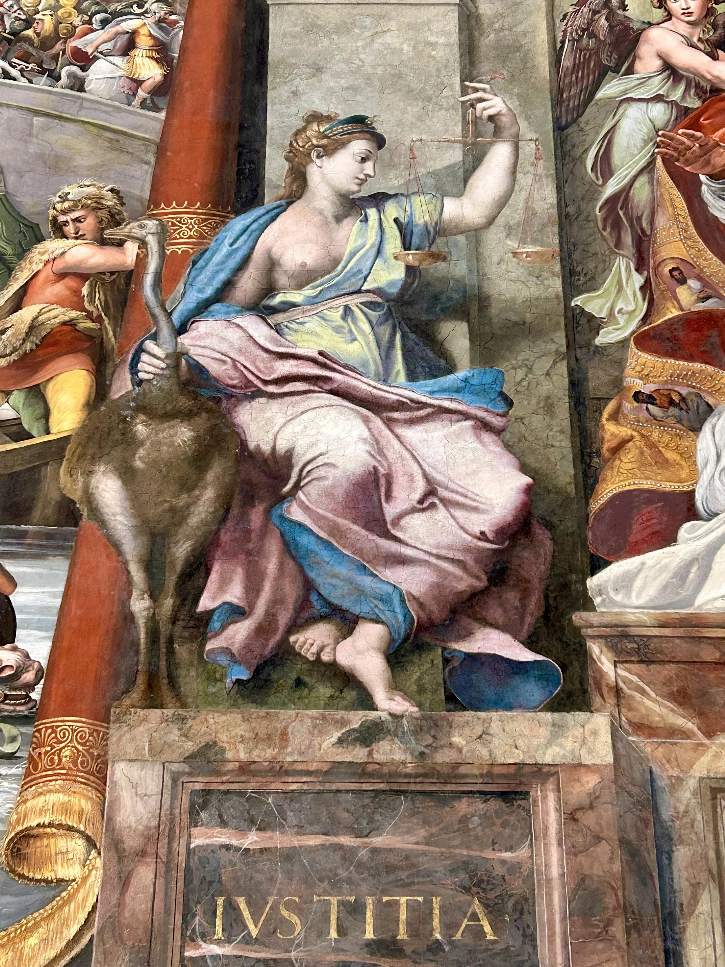 Particolare di un affresco o dipinto raffigurante una figura femminile con una bilancia in mano e un ermafrodito con barba e vestiti, probabilmente una scena mitologica o allegorica.