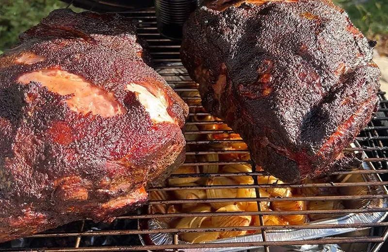 Pork butts on the smoker with onions