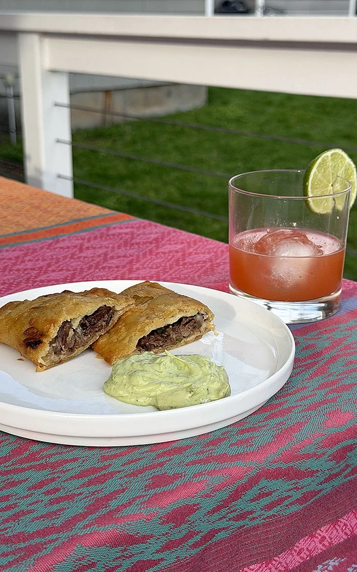 Short rib empanadas with avocado crema and bright citrus cocktail