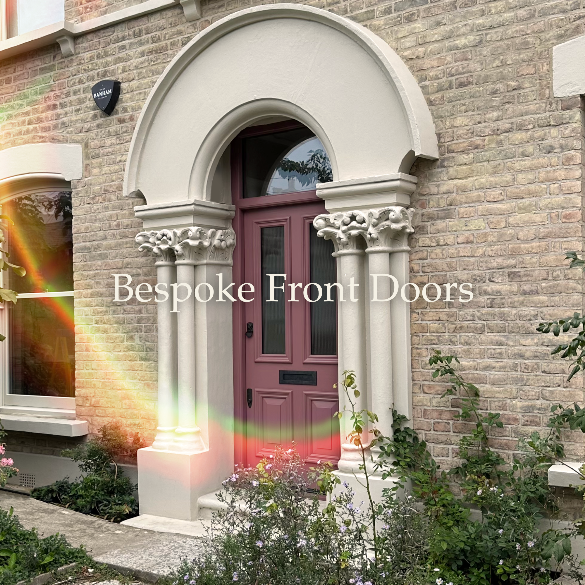 A house front with a purple door under an arched doorway with ornate stone columns, brick walls, a window to the left, and plants in front, with the text "Bespoke Front Doors" overlayed.
