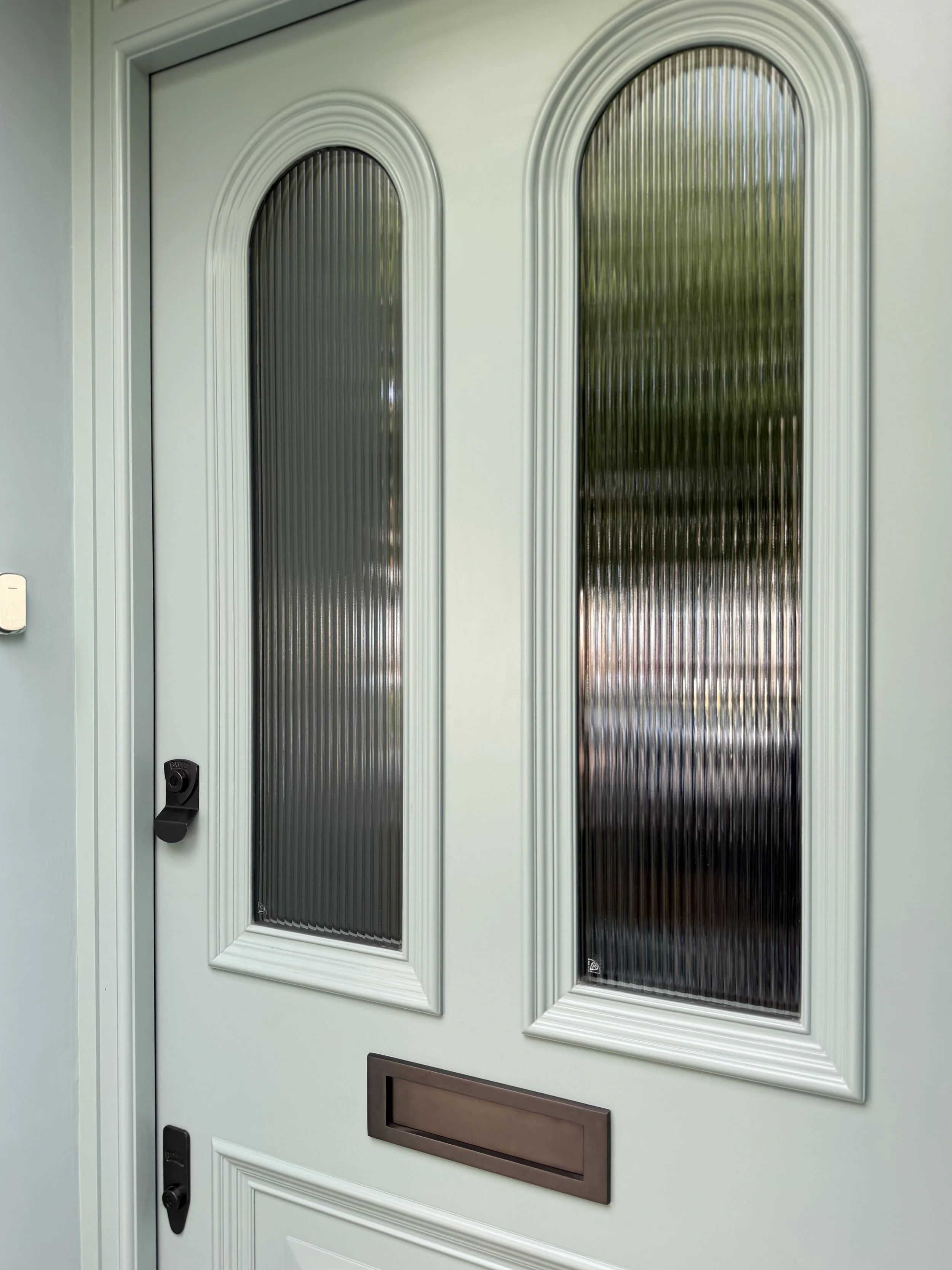 A three-panel, Victorian-inspired door,  featuring ornate bolection mouldings, arched reeded glass and a bold projecting lower panel.