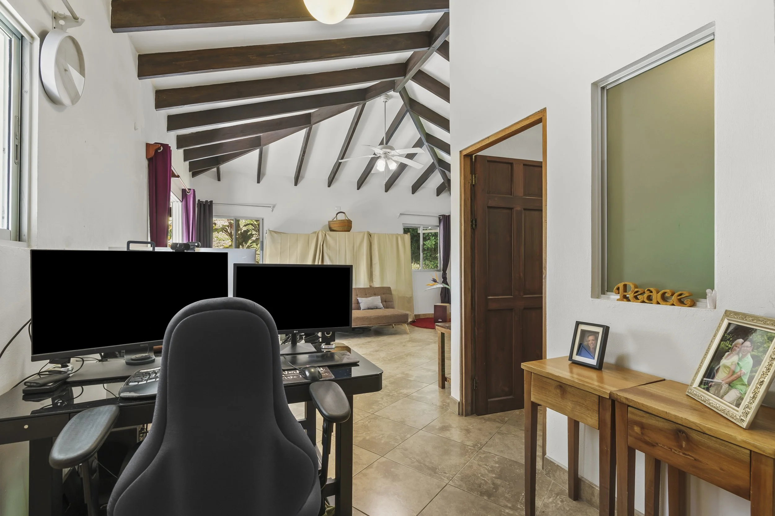 Spacious primary bedroom with room for a comfortable remote workspace overlooking the jungle.